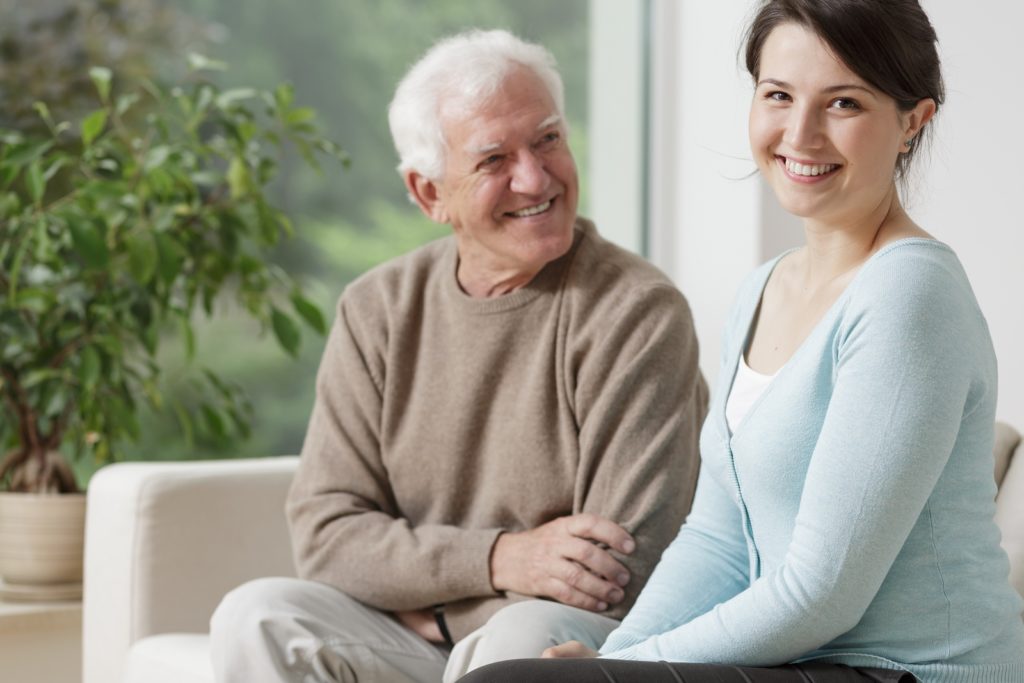 Smiling grandpa and caring granddaughter at home